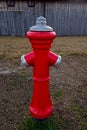 Red fire hydrant next to a barn Royalty Free Stock Photo